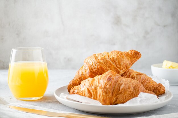 Petit déjeuner avec croissants et jus d'orange.