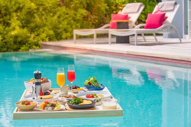 Petit-déjeuner dans la piscine, petit-déjeuner flottant dans un complexe tropical. Table relaxante dans l'eau calme de la piscine