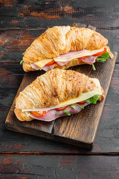 Petit-déjeuner, déjeuner d'affaires, ensemble de croissants sandwiches, sur le vieux fond de table en bois sombre