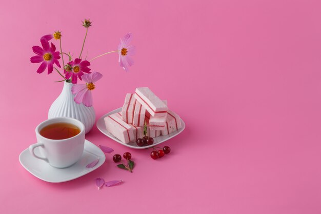 Petit déjeuner ou déjeuner léger, cerise, baies et thé noir sur fond rose