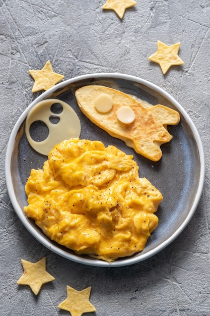 Petit-déjeuner drôle pour enfants avec œufs brouillés, fromage et fusée spatiale tortilla