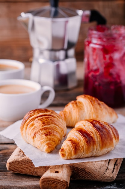 Petit-déjeuner du matin Croissants faits maison avec de la confiture et du café sur fond rustique en bois