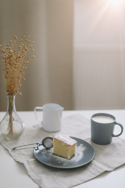 Le petit-déjeuner du matin avec un morceau de pichet à gâteau fait maison et une tasse de café sur une table