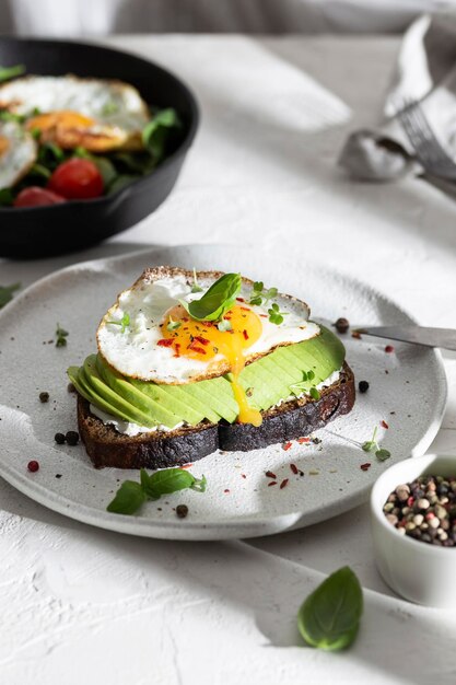 Photo petit-déjeuner avec du pain grillé, de l'avocat et des œufs dans une assiette