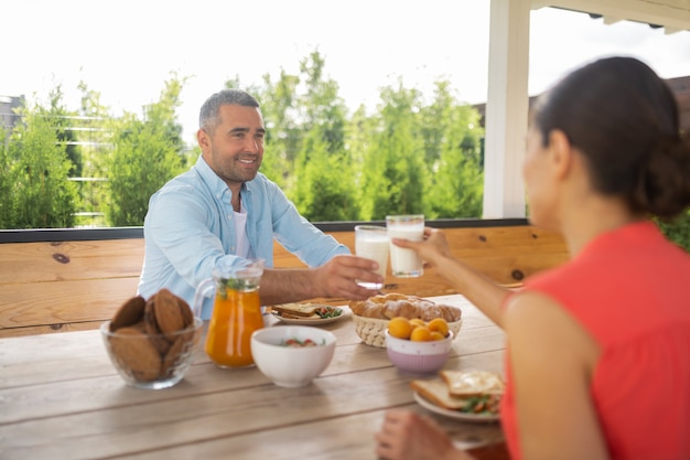 Petit déjeuner du week-end. Couple se sentant heureux tout en prenant un délicieux petit-déjeuner à l'extérieur le week-end