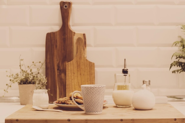 Un petit-déjeuner avec du yaourt au lait et une tasse de café sur le plan de travail de la cuisine