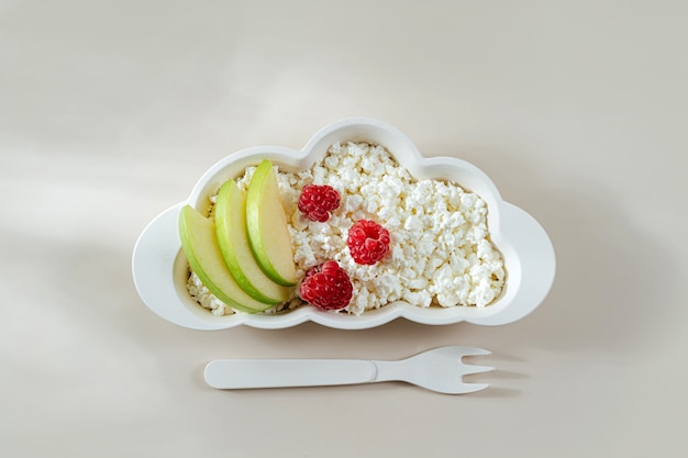 Petit-déjeuner des enfants. Assiette en forme de nuage avec du fromage cottage et des baies. Idée de nourriture pour les enfants.