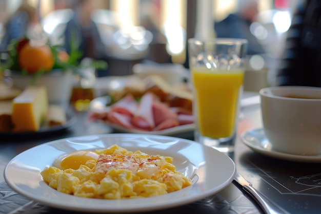 Le petit déjeuner est servi avec du café, du jus d'orange, des œufs brouillés, des céréales, du jambon et du fromage.