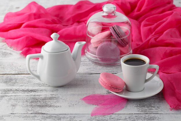 Petit déjeuner de femme avec tasse de café et macarons roses