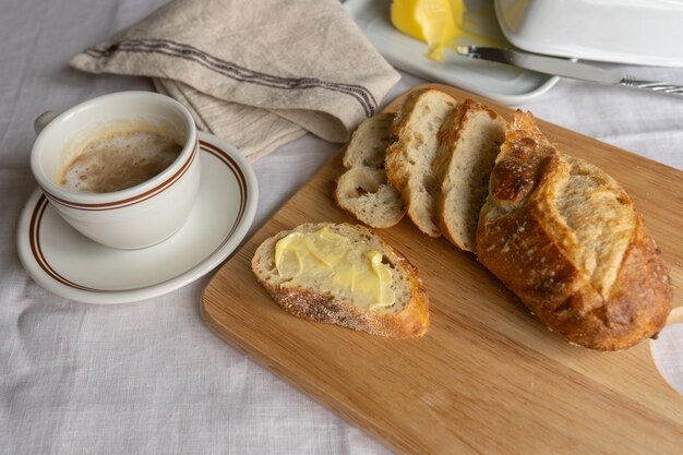 Photo un petit déjeuner français, du café avec du lait, du pain tranché et un plat au beurre, un délicieux mélange de mo.