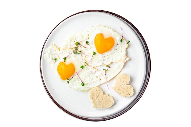 Petit-déjeuner frit aux œufs de saint valentin sur la table des œufs brouillés décoration de vacances en forme de coeur amour