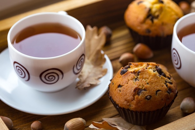 Petit-déjeuner - gâteau et tasse de thé sur un plateau en bois