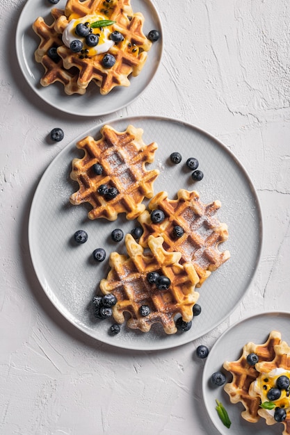 Petit-déjeuner avec gaufres aux myrtilles et sirop sur une assiette