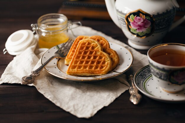 Petit déjeuner avec des gaufrettes et une tasse de thé