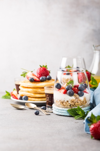 Petit déjeuner avec granola, crêpes et petits fruits