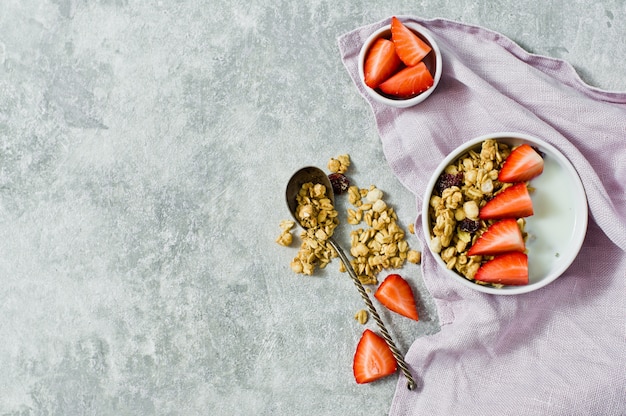 Petit déjeuner avec granola, fraises et yaourt.