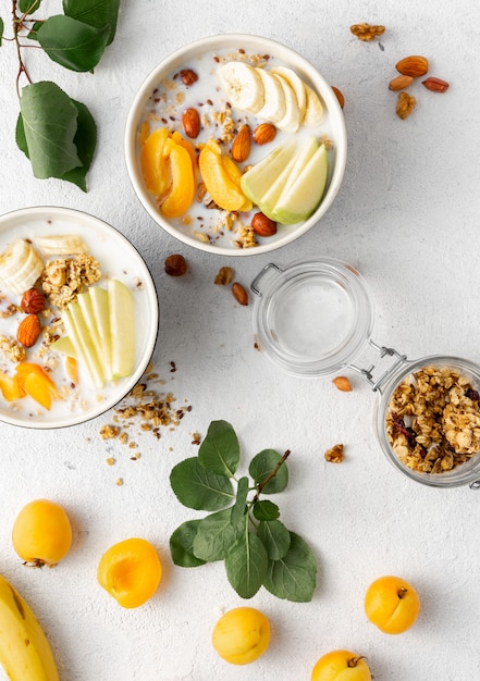 Petit déjeuner granola avec fruits, noix, lait et beurre de cacahuète dans un bol. Vue de dessus des céréales pour le petit déjeuner