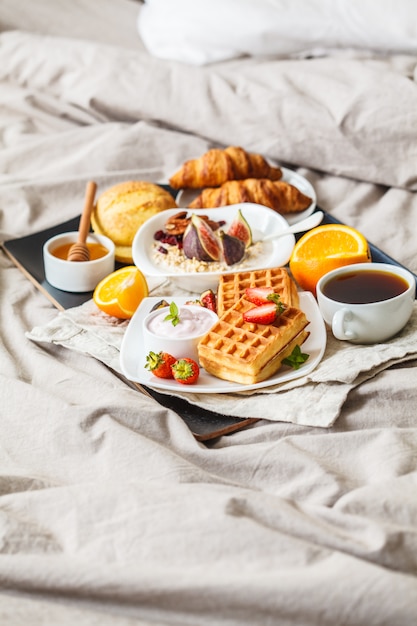 Petit Déjeuner Avec Gruau, Gaufres, Café, Croissants Et Fruits Au Lit.