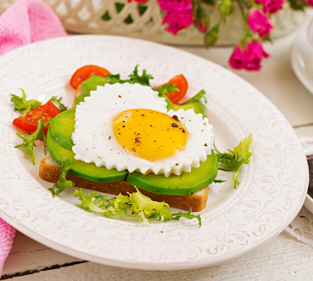 Petit Déjeuner Le Jour De La Saint-valentin - Sandwich à L'oeuf Au Plat En Forme De Cœur, Avocat Et Légumes Frais. Tasse De Café. Petit Déjeuner Anglais.