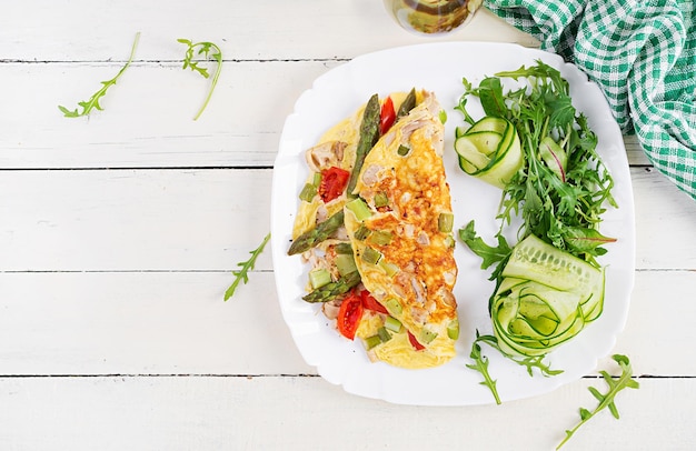 Petit-déjeuner Keto Omelette avec filet de poulet tomates et asperges sur une table en bois blanche Frittata italienne Déjeuner cétogène Keto Vue de dessus espace de copie au-dessus