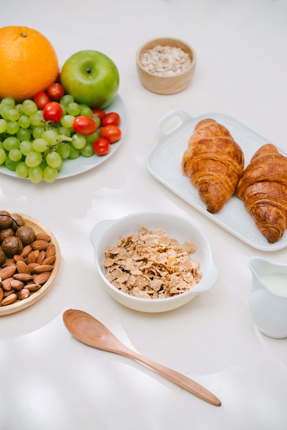 Petit-déjeuner léger et sain avec de la farine d'avoine. Hercule, noix, fruits, œufs durs, pain. Vaisselle. La nourriture saine.