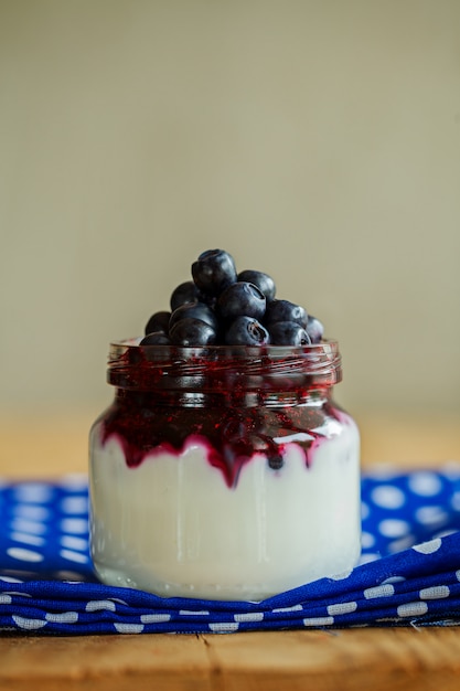 Petit déjeuner léger avec yaourt, confiture et bleuets en vrac.