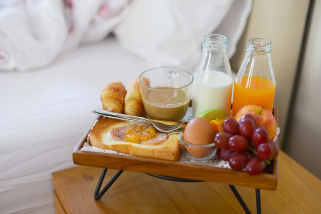 Petit déjeuner sur le lit avec café, croissants