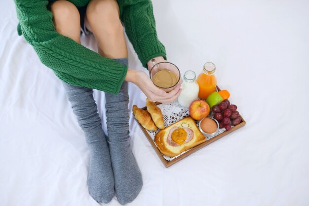 Petit déjeuner sur le lit avec café, croissants