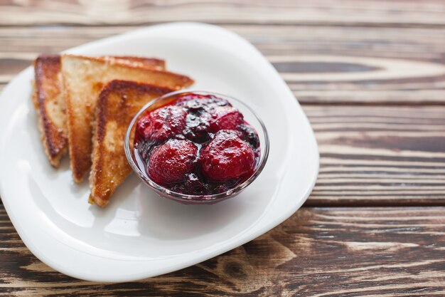 Petit déjeuner le matin. Toasts à la fraise et à la confiture. Pain et confiture. Toasts chauds frais avec de la crème. Délicieux dessert fait maison.