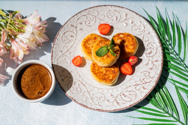 petit-déjeuner matinal avec des crêpes au fromage et une tasse de café au soleil au restaurant