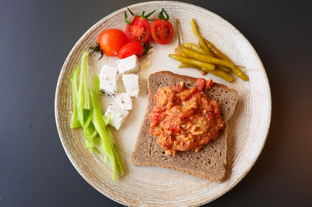 Petit-déjeuner matinal avec des œufs brouillés sur un pain sur une assiette blanche