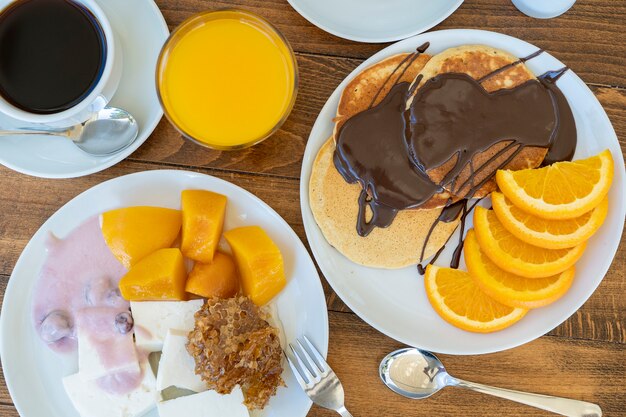 Petit-déjeuner de nombreux plats et boissons sur une table en bois, gros plan. Notion de nourriture