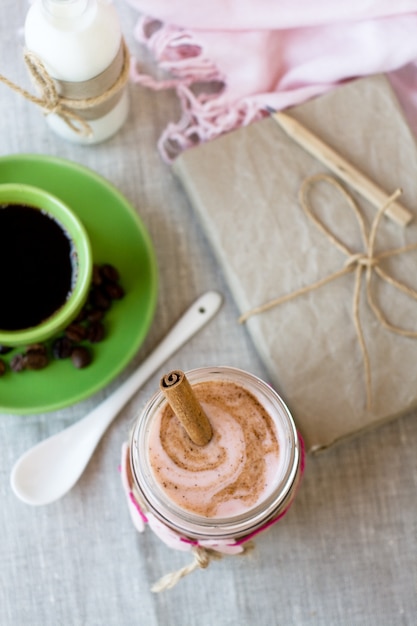 Petit déjeuner nutritif: flocons d'avoine avec yaourt aux baies et cannelle, café noir et une bouteille de lait.