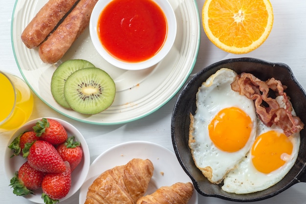 Petit déjeuner nutritif, fraise, pain, jus d&#39;orange de café, saucisse, oeuf