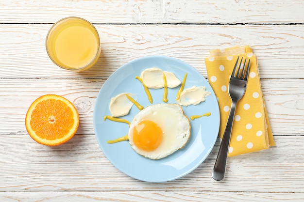 Petit déjeuner d'oeuf au plat et jus d'orange sur table en bois, vue du dessus