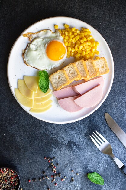 Petit-déjeuner oeuf au plat pain pain grillé fromage maïs et plus sur la table servant des collations repas sains