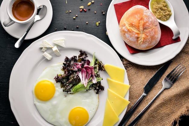 Petit-déjeuner Oeuf et Burger Bœuf Friture de pommes de terre Sur un fond en bois Vue de dessus Espace libre pour le texte