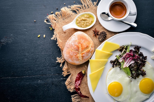 Petit-déjeuner Oeuf et Burger Bœuf Friture de pommes de terre Sur un fond en bois Vue de dessus Espace libre pour le texte