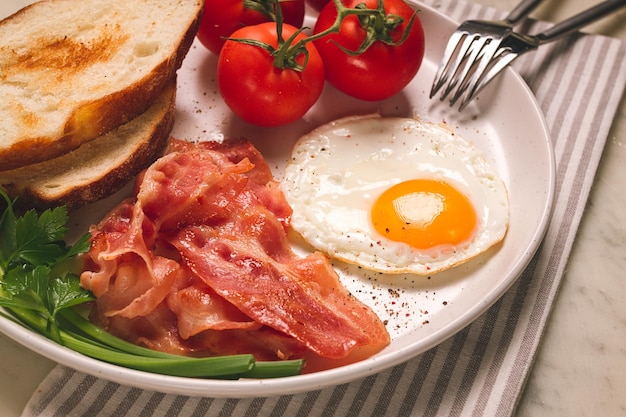 Petit-déjeuner œuf frit bacon et pain avec cerise sur fond clair fait maison sans personne