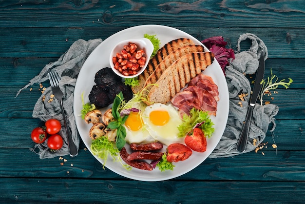 Petit-déjeuner Oeufs au bacon et tomates pain grillé Vue de dessus Sur un fond en bois Copier l'espace