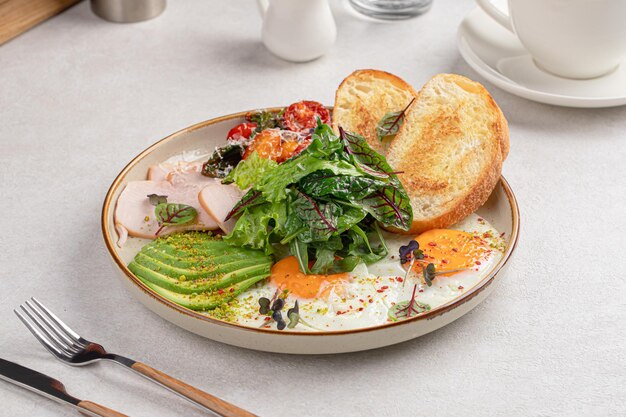 Petit déjeuner d'oeufs au plat avec salade et avocat