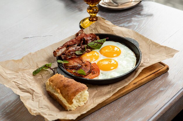 Petit-déjeuner d'œufs et de bacon, servi avec des pâtisseries fraîches et du jus de tomate