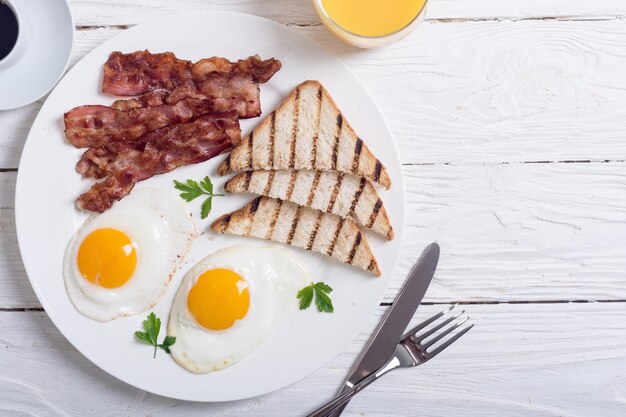 Petit-déjeuner avec œufs, bacon et toasts Fond alimentaire