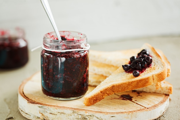 Petit déjeuner avec pain grillé et confiture de baies fraîches sur la table.