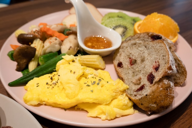 Petit déjeuner de pain, légumes et fruits sur un plat le matin