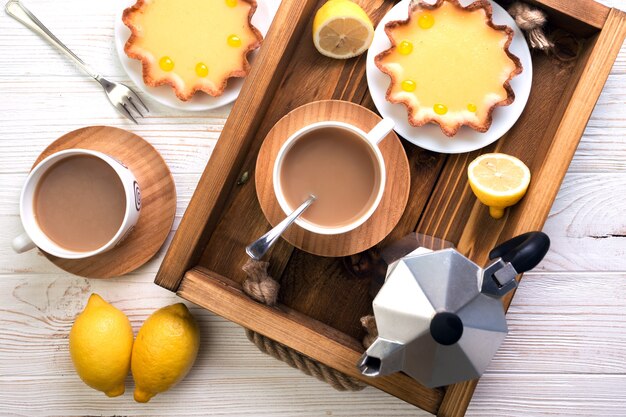 Petit déjeuner - un plateau de tartes au citron et café