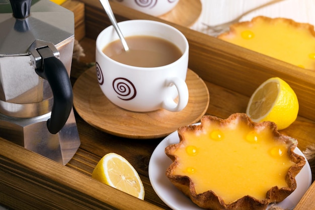 Petit-déjeuner - un plateau de tartes au citron et café