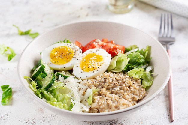 Photo petit déjeuner porridge d'avoine avec des œufs bouillis tomates concombres et oignons nourriture saine et équilibrée nourriture à la mode