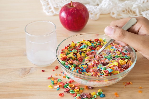 Petit déjeuner rapide sain Céréale de riz coloré avec du lait et pomme pour enfants sur fond en bois. Espace de copie