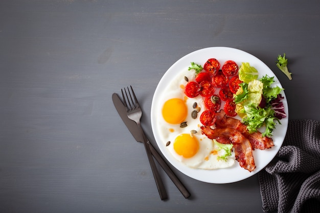 Petit-déjeuner régime céto sain: œuf, tomates, feuilles de salade et bacon